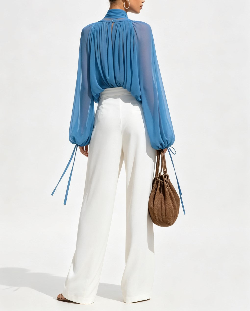 Ensemble composé d'un haut en mousseline à col montant, profond décolleté en V et manches lanternes transparentes et d'un pantalon large drapé taille haute